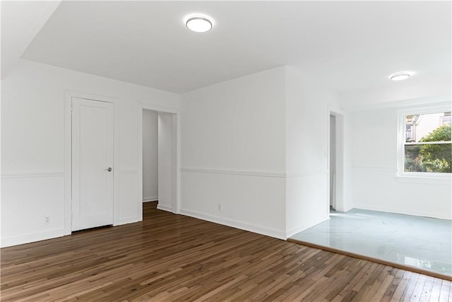 unfurnished room featuring dark wood-type flooring