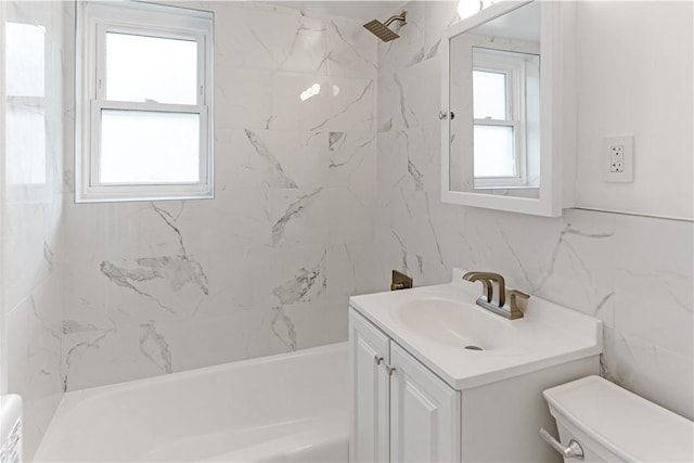 full bathroom featuring vanity, toilet, tile walls, and tiled shower / bath combo