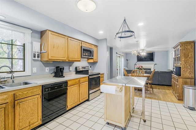 kitchen featuring a kitchen breakfast bar, sink, ceiling fan, light tile patterned floors, and appliances with stainless steel finishes