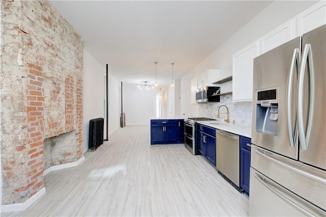 kitchen with backsplash, blue cabinets, light hardwood / wood-style flooring, white cabinetry, and stainless steel appliances