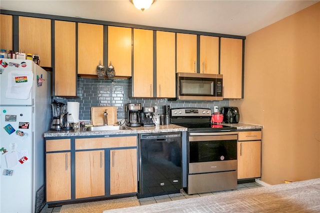 kitchen featuring light tile patterned floors, sink, appliances with stainless steel finishes, and tasteful backsplash