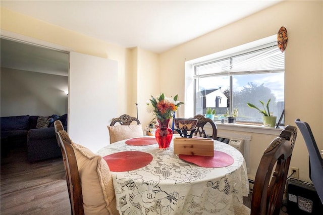 dining area with a baseboard heating unit and hardwood / wood-style flooring