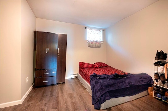 bedroom with a baseboard radiator and light hardwood / wood-style flooring