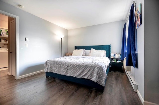 bedroom featuring baseboard heating, dark hardwood / wood-style floors, and washer / dryer