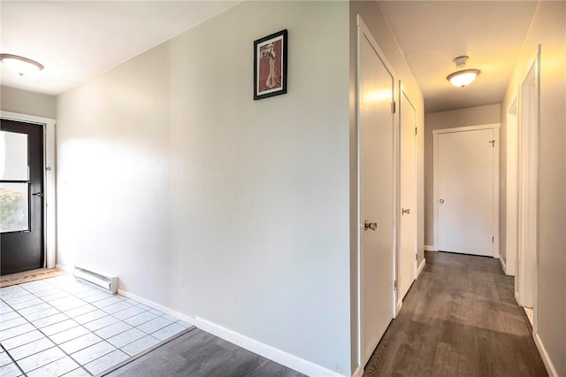 hallway with a baseboard radiator and light hardwood / wood-style flooring