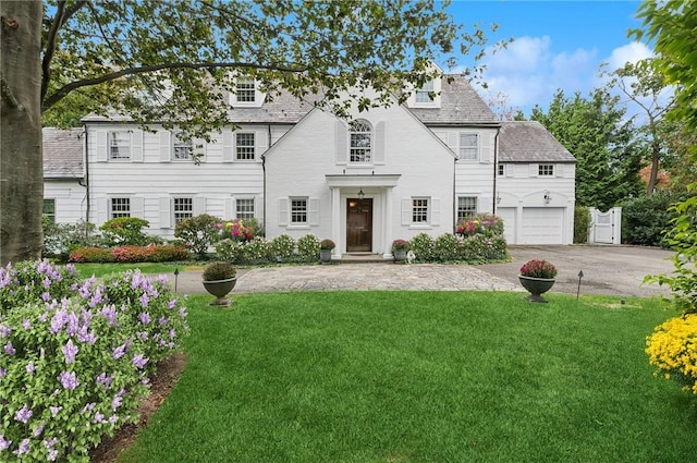 view of front of property featuring a garage and a front lawn