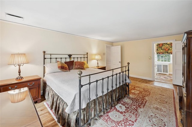 bedroom featuring radiator heating unit and light hardwood / wood-style floors