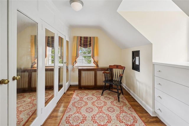 sitting room with vaulted ceiling, hardwood / wood-style floors, and french doors