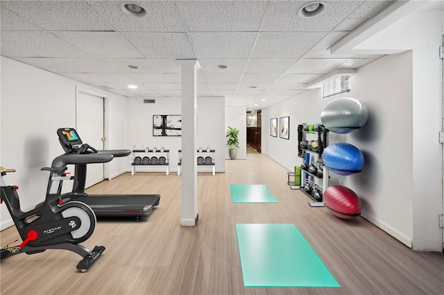 workout room featuring a paneled ceiling and hardwood / wood-style flooring