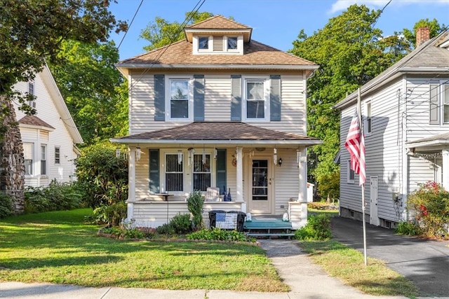 view of front facade with a front lawn and covered porch