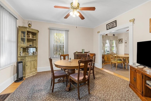 carpeted dining area featuring ceiling fan and ornamental molding