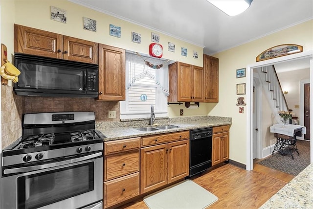 kitchen featuring crown molding, sink, black appliances, and light wood-type flooring