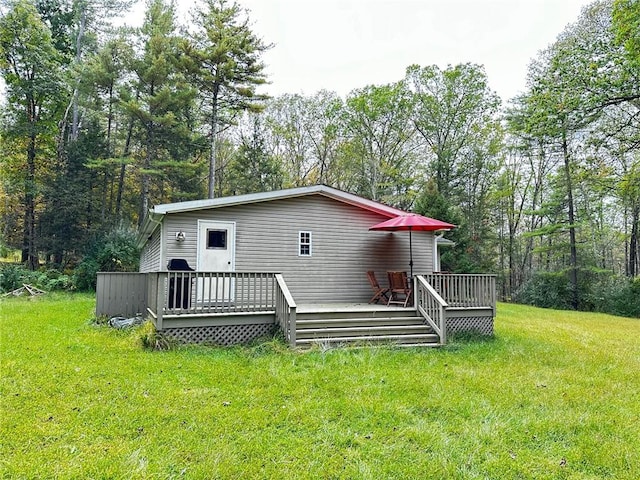 rear view of house featuring a yard and a deck