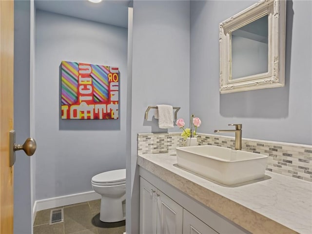 bathroom with tile patterned floors, decorative backsplash, vanity, and toilet