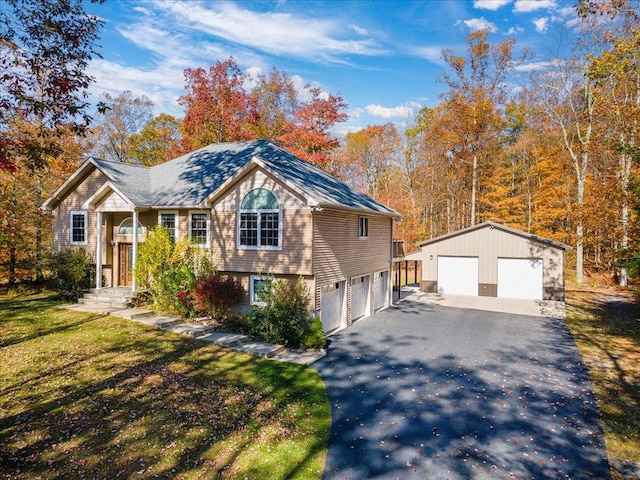 view of front of home featuring a garage, an outbuilding, and a front yard