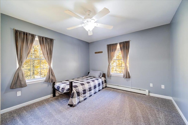 carpeted bedroom with ceiling fan, multiple windows, and a baseboard heating unit