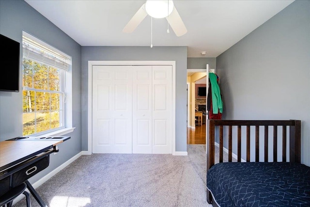 carpeted bedroom featuring ceiling fan and a closet