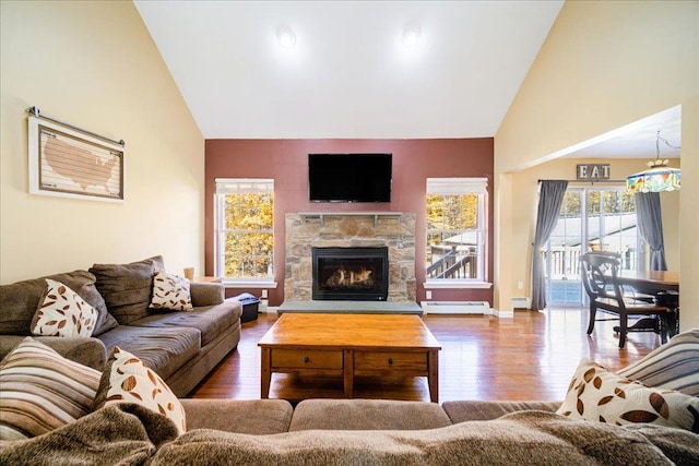 living room with a fireplace, hardwood / wood-style floors, high vaulted ceiling, and a baseboard radiator