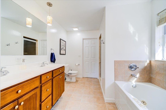 bathroom with tile patterned floors, a tub to relax in, vanity, and toilet