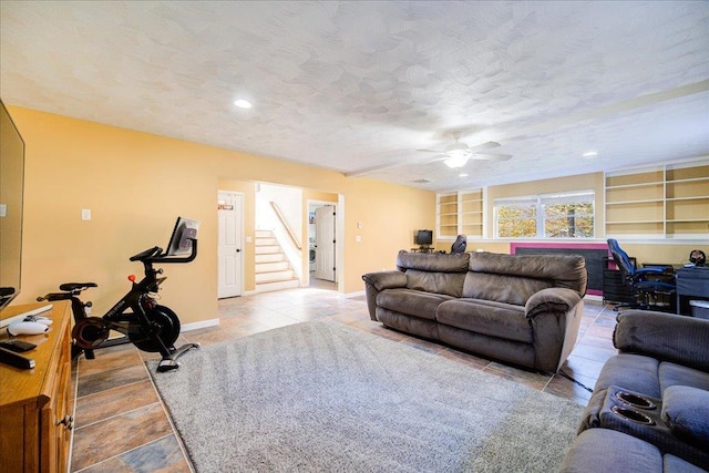 living room featuring a textured ceiling, built in features, and ceiling fan