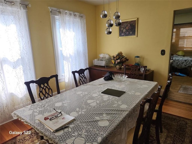 dining room with hardwood / wood-style floors and a notable chandelier