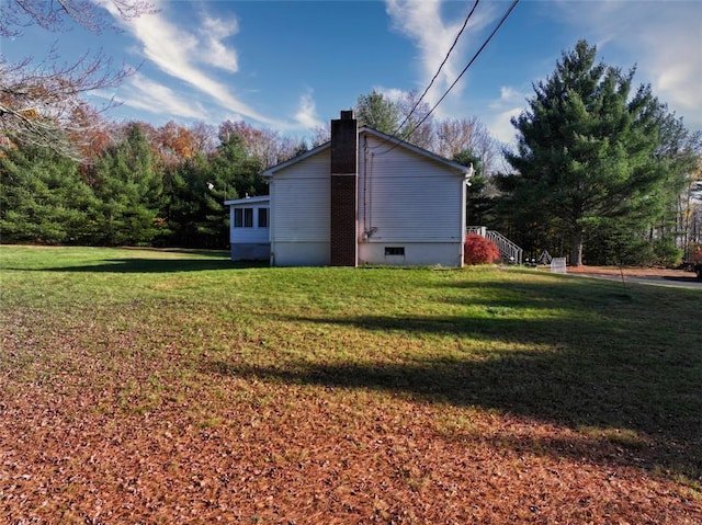 view of side of home with a yard