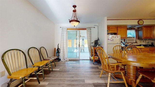 dining area featuring cooling unit and wood-type flooring