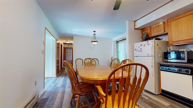 dining area with wood-type flooring and baseboard heating