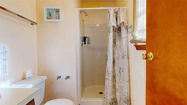 bathroom featuring vanity, toilet, and walk in shower