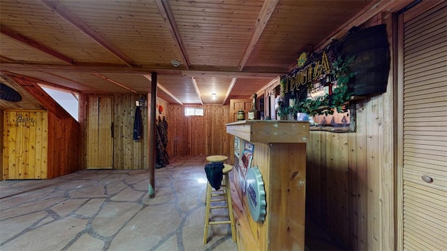 basement with indoor bar and wood walls