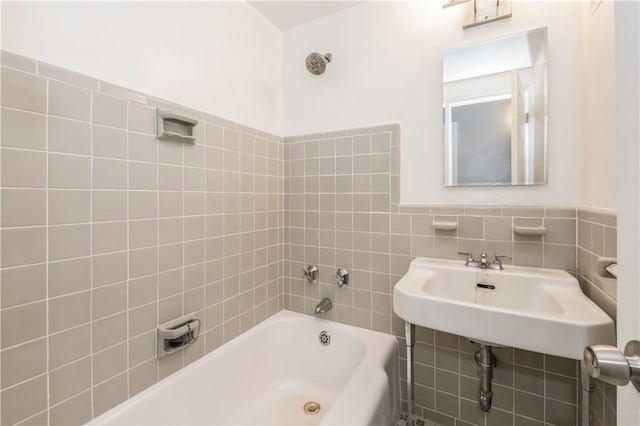 bathroom featuring a tub, sink, and tile walls