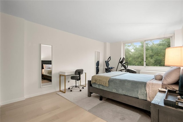 bedroom with light hardwood / wood-style floors and vaulted ceiling