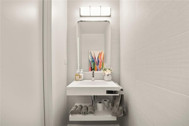 bathroom with tile walls and sink