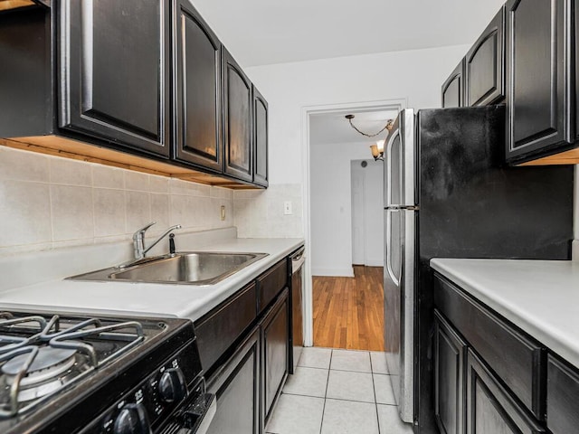 kitchen featuring tasteful backsplash, sink, light tile patterned flooring, and stainless steel appliances