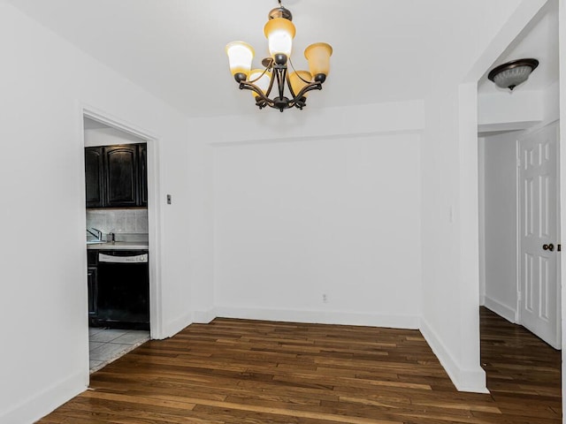 unfurnished dining area featuring dark hardwood / wood-style floors and an inviting chandelier