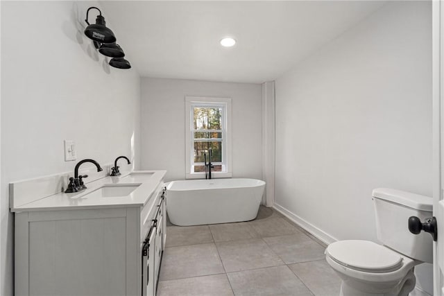 bathroom featuring tile patterned floors, a bathtub, toilet, and vanity