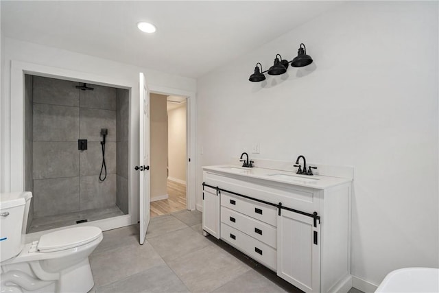 bathroom featuring vanity, toilet, and a tile shower