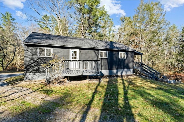 back of house with a deck and a yard