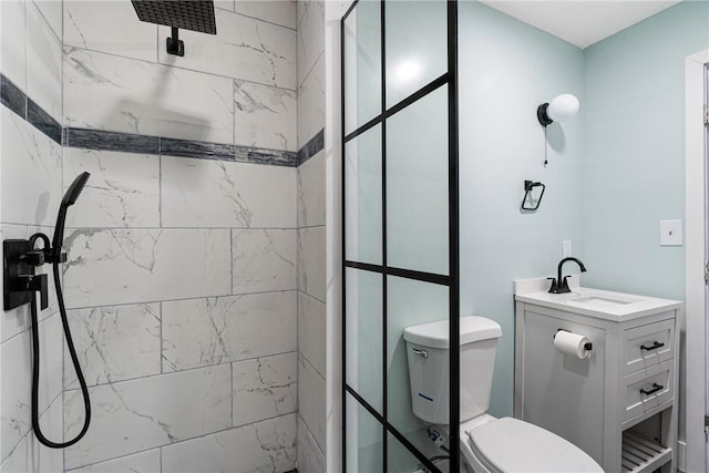 bathroom featuring vanity, toilet, and tiled shower