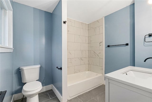 full bathroom featuring tile patterned floors, tiled shower / bath, vanity, and toilet