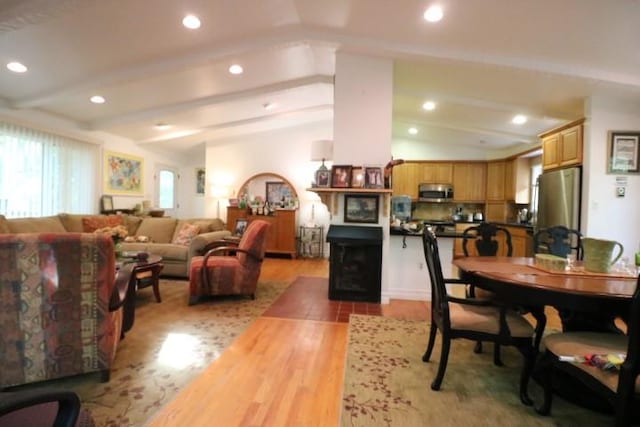 dining area featuring hardwood / wood-style floors and vaulted ceiling with beams