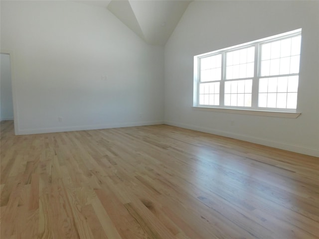 spare room featuring light hardwood / wood-style floors and lofted ceiling