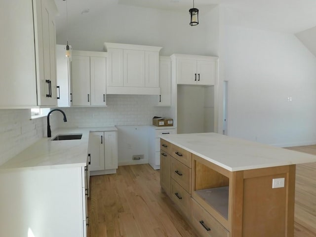 kitchen with a center island, white cabinetry, pendant lighting, and tasteful backsplash