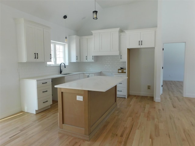 kitchen with white cabinets, a center island, decorative backsplash, and hanging light fixtures