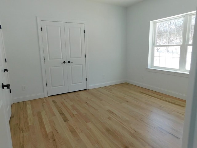 unfurnished bedroom featuring light hardwood / wood-style flooring and a closet