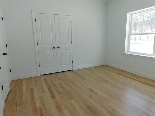 unfurnished bedroom featuring light hardwood / wood-style floors and a closet