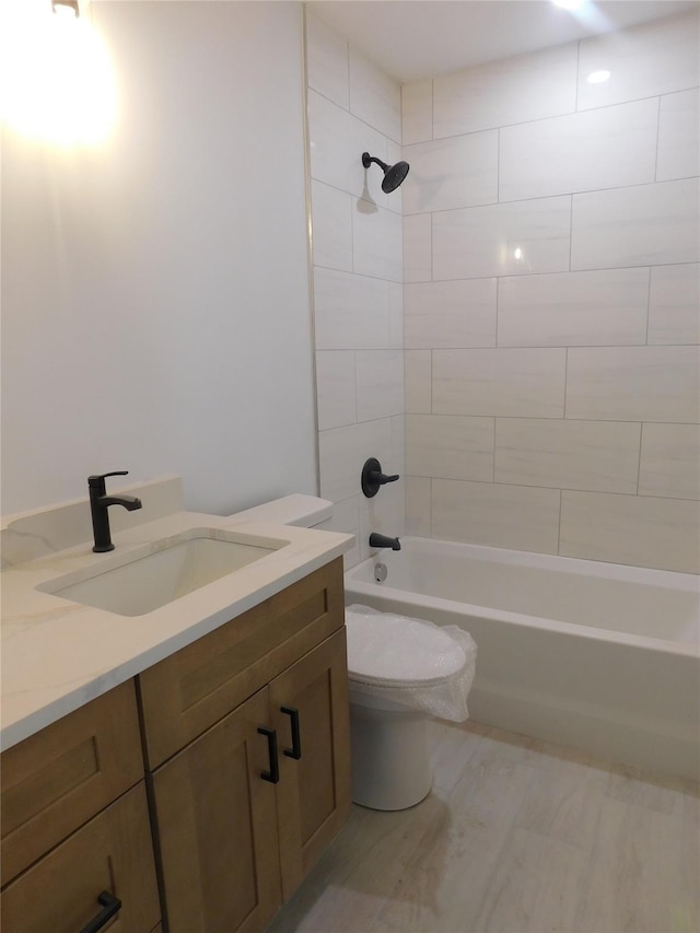 full bathroom with tiled shower / bath combo, toilet, and vanity