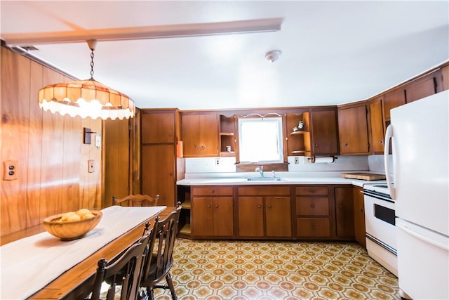 kitchen featuring pendant lighting, white appliances, and sink