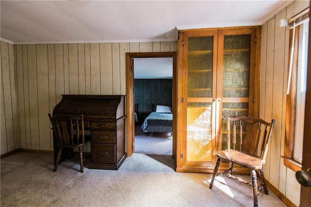 carpeted office featuring crown molding and wood walls