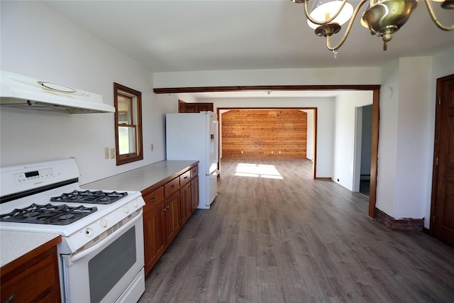 kitchen featuring white appliances, dark wood-type flooring, and a notable chandelier